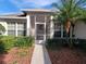 A close-up view of a screen-enclosed porch with a walkway and manicured greenery at 3567 Capland Ave, Clermont, FL 34711