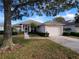 Charming single-story home with a two-car garage and a well-manicured front yard and screen enclosed front porch at 3567 Capland Ave, Clermont, FL 34711