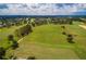 Scenic aerial shot of the sprawling golf course with lush green fairways and mature trees at 3567 Capland Ave, Clermont, FL 34711