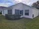 Exterior view of the home features a lawn, hedges and screened-in porch at 3567 Capland Ave, Clermont, FL 34711