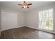 Bright bedroom featuring a window with blinds, closet with sliding doors, and wood-look laminate flooring at 385 Wymore Rd # 200, Altamonte Springs, FL 32714