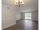 Open-concept living space featuring laminate flooring, white trim, and a chandelier at 385 Wymore Rd # 200, Altamonte Springs, FL 32714