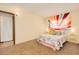 Bedroom featuring a sunburst wall tapestry, bedside tables, and carpet flooring at 400 Oakridge Blvd # 5, Daytona Beach, FL 32118