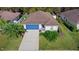 Aerial view of a home with a blue garage door, green lawn, and mature landscaping at 43 Pergola Pl, Ormond Beach, FL 32174