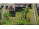 Aerial view of a spacious backyard with lush green grass, palm trees, and a covered patio at 43 Pergola Pl, Ormond Beach, FL 32174