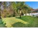 Expansive backyard with well-manicured lawn, mature trees, and a view of the covered patio at 43 Pergola Pl, Ormond Beach, FL 32174