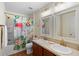 Bathroom featuring double sinks, decorative mirrors, and a shower with a vibrant flamingo-themed curtain at 43 Pergola Pl, Ormond Beach, FL 32174