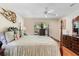 Bright bedroom with a four-poster bed, wood floors, and a dresser near the window at 43 Pergola Pl, Ormond Beach, FL 32174