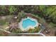 Aerial view of community pool with plenty of lounge chairs and surrounded by trees at 43 Pergola Pl, Ormond Beach, FL 32174