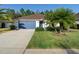 Beautiful one-story home with a well-manicured lawn and a blue two-car garage door at 43 Pergola Pl, Ormond Beach, FL 32174