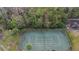 Aerial view of the fenced in community tennis court surrounded by trees at 43 Pergola Pl, Ormond Beach, FL 32174