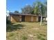 Home's front is boarded up, surrounded by unkempt yard, conveying a property in disrepair and in need of renovation at 4384 Frances Ave, Sanford, FL 32773