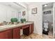 Dual sink bathroom featuring a large mirror, wood vanities, tiled floors, and an adjacent toilet at 4515 Sea Biscut Ct, Orlando, FL 32818