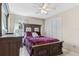 Cozy bedroom with a plush bed, neutral decor, a ceiling fan, and ample natural light through a window at 4515 Sea Biscut Ct, Orlando, FL 32818