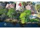 Aerial view of a lakeside house showing mature trees and landscaping near the water's edge at 500 Pickfair Ter, Lake Mary, FL 32746