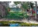 Backyard view of house featuring a well-maintained lawn and lush vegetation along the waterfront at 500 Pickfair Ter, Lake Mary, FL 32746