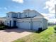 A charming two-story home featuring a three-car garage, a well-manicured lawn, and a brick paved driveway at 5030 Tibet Ct, St Cloud, FL 34772