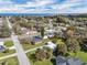 An aerial perspective reveals a charming community near a lake, featuring diverse home styles and tree-lined streets at 513 Wisconsin Ave, St Cloud, FL 34769