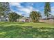 Expansive fenced backyard featuring lush green grass and mature trees at 513 Wisconsin Ave, St Cloud, FL 34769