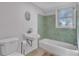 A well-lit bathroom features a shower-tub and tiled walls at 513 Wisconsin Ave, St Cloud, FL 34769