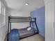 Bedroom features a bunk bed, blue accent wall, closet, and cozy carpet at 513 Wisconsin Ave, St Cloud, FL 34769