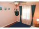 Cozy bedroom features a ceiling fan, wood floors, natural light, and warm peach colored walls at 5521 Rutherford Pl, Oviedo, FL 32765