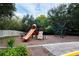 Outdoor playground area with a slide, climbing structure, and other play equipment at 5521 Rutherford Pl, Oviedo, FL 32765