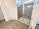 Bathroom features a glass-enclosed shower with gray tile surround and a view into the ensuite at 6004 Oak Green Loop, Davenport, FL 33837