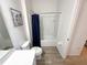 Bright bathroom with a shower-tub, framed artwork, and wood-look tile flooring at 6004 Oak Green Loop, Davenport, FL 33837