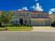 Stately two-story home with a three-car garage, tile roof, and manicured landscaping at 6004 Oak Green Loop, Davenport, FL 33837