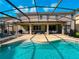 Expansive screened-in pool area with tanning chairs and outdoor dining, ideal for entertaining guests at 6004 Oak Green Loop, Davenport, FL 33837