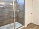 The tiled shower stall is equipped with a glass door and modern fixtures at 6004 Oak Green Loop, Davenport, FL 33837