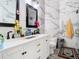 Bright bathroom featuring a double sink vanity, black fixtures, and elegant marble-style tiling at 7214 Rex Hill Trl, Orlando, FL 32818