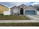 Charming single Gathering home with large garage and manicured front yard with blue shutters and blue garage door at 7214 Rex Hill Trl, Orlando, FL 32818