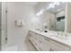 Well-lit bathroom features double vanity, decorative mirror and glass enclosed shower with unique tile accents at 7465 Gathering Loop, Reunion, FL 34747