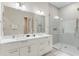 Well-lit bathroom featuring dual sinks, a large mirror, and a glass-enclosed shower at 7465 Gathering Loop, Reunion, FL 34747