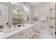 Elegant bathroom featuring double vanity, large mirror, and glass enclosed shower with decorative tile accents at 7465 Gathering Loop, Reunion, FL 34747