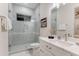 Clean bathroom featuring a glass enclosed shower, window, and white vanity at 7465 Gathering Loop, Reunion, FL 34747