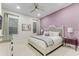 Elegant bedroom with a lavender accent wall, king size bed, and glass bedside tables at 7465 Gathering Loop, Reunion, FL 34747