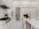 Gourmet kitchen boasts white cabinetry, stainless steel appliances, and marble countertops at 7465 Gathering Loop, Reunion, FL 34747