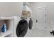 Bright laundry room with a Whirlpool washer and dryer and white cabinets at 7465 Gathering Loop, Reunion, FL 34747