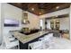 An outdoor kitchen with a built-in grill, bar seating, and a beautiful wood ceiling at 7465 Gathering Loop, Reunion, FL 34747