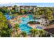 Aerial view of a resort-style pool with palm trees, water slides, and a sprawling complex at 7671 Otterspool St, Kissimmee, FL 34747