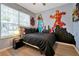 bedroom with superhero wall art, black bedding and wood laminate flooring at 7671 Otterspool St, Kissimmee, FL 34747