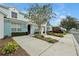 View of townhouse showcasing blue exterior, individual parking spots, and tidy landscaping at 7671 Otterspool St, Kissimmee, FL 34747