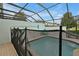 View of a pool with a safety fence, surrounded by brick pavers and a screened enclosure at 7671 Otterspool St, Kissimmee, FL 34747