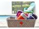 Poolside towels in a gray patterned basket, with a glimpse of the pool and aqua chair in background at 7671 Otterspool St, Kissimmee, FL 34747