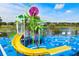 View of the splash pad with colorful equipment and a pond with a fountain on a bright and sunny day at 7671 Otterspool St, Kissimmee, FL 34747