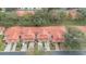 Aerial view showcases the townhomes with red-tiled roofs and the surrounding lush landscape at 7709 Sundial Ln, Orlando, FL 32819