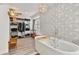 Bathroom featuring a modern tub and patterned wall with storage and natural light at 7709 Sundial Ln, Orlando, FL 32819